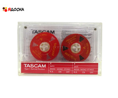 Аудиокассета "TASCAM" с катушками красного цвета с жёлтым текстом